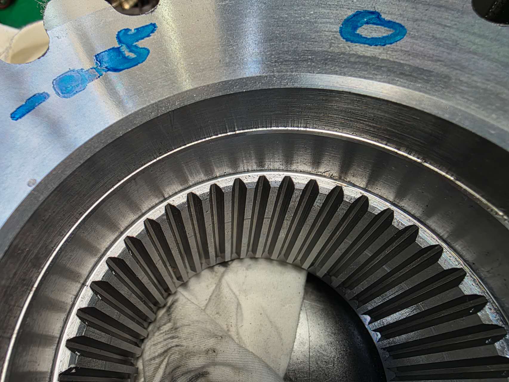 Close-up of the newly developed pinion / ring-gear teeth with blue layout marking ink — module, tooth count and pressure angle all adjusted to fit the customer's existing drivetrain geometry.