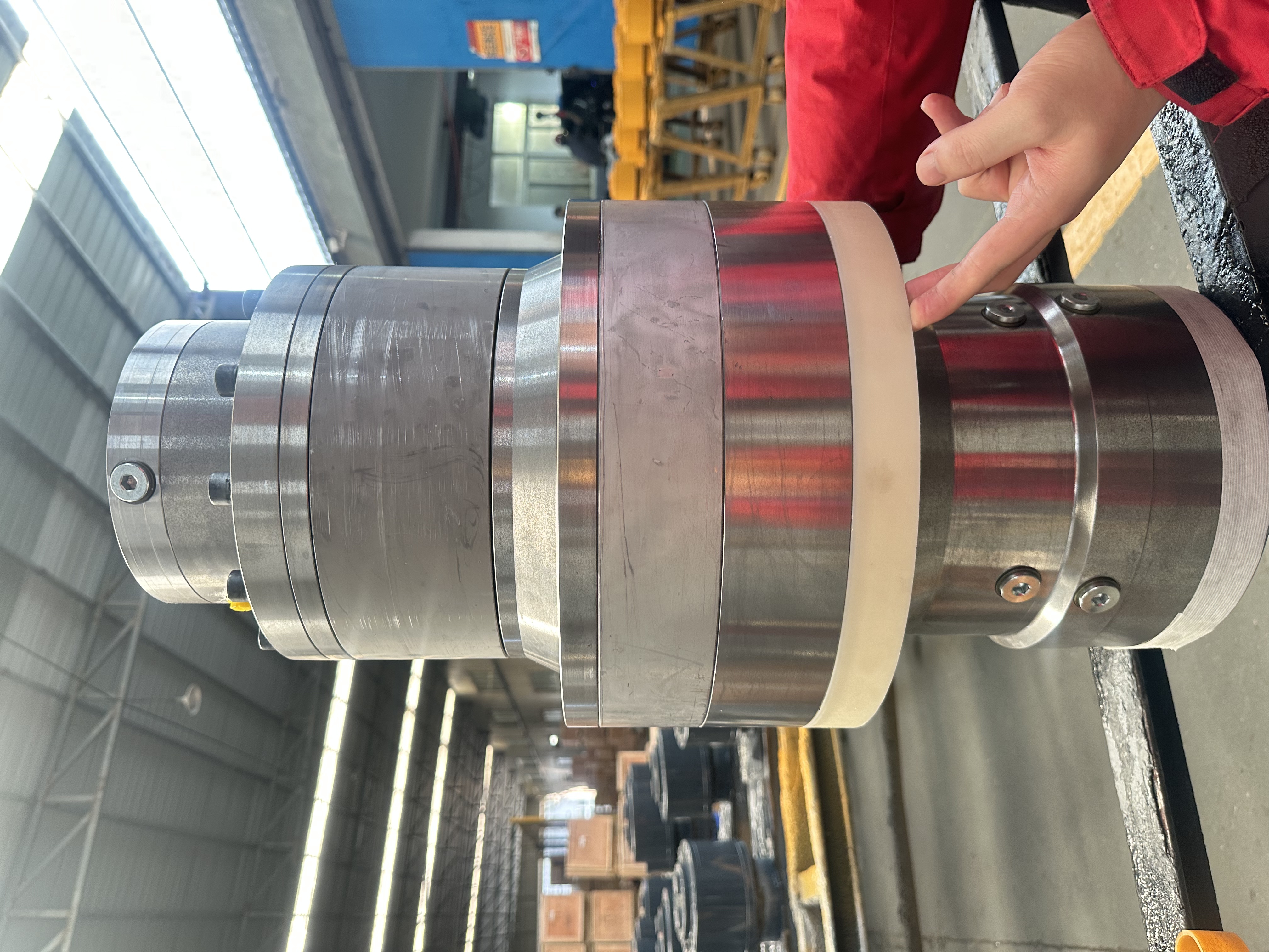 The finished ZCM-series swing drive transmission held up on the shop floor — the stacked gearbox-and-motor assembly, machined and inspected before shipment.