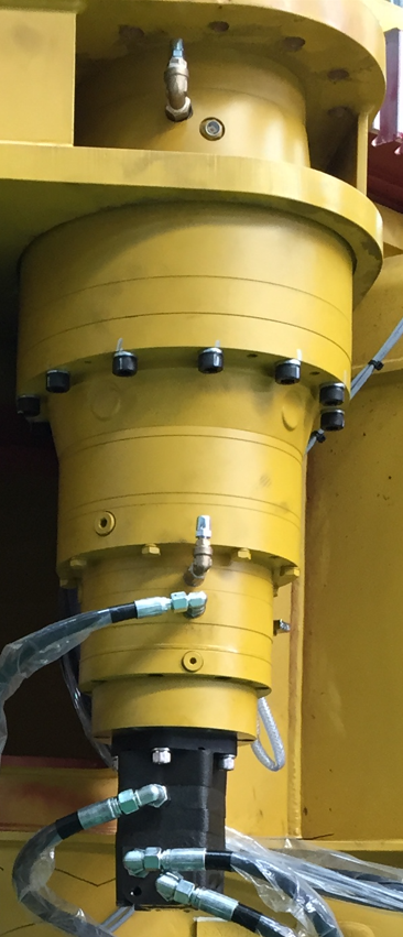 The assembled swing drive installed on the boom base — orbital motor at the bottom feeding the planetary gearbox above, with hydraulic lines connected.