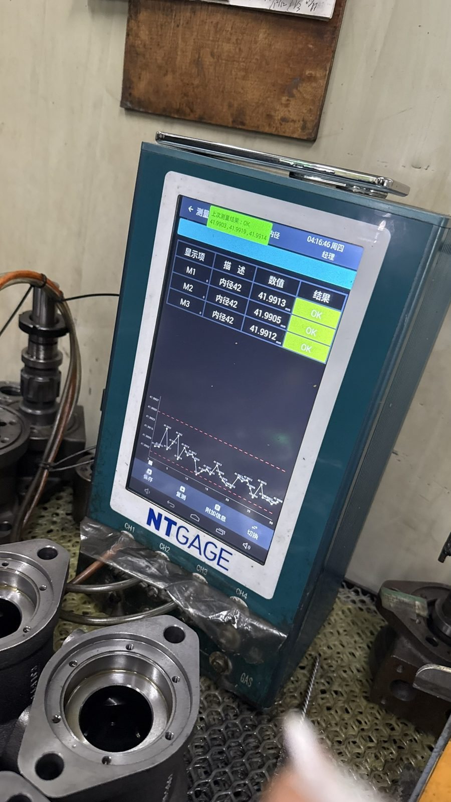 Digital bore gauge displaying measurement and automatic OK judgment on a motor housing