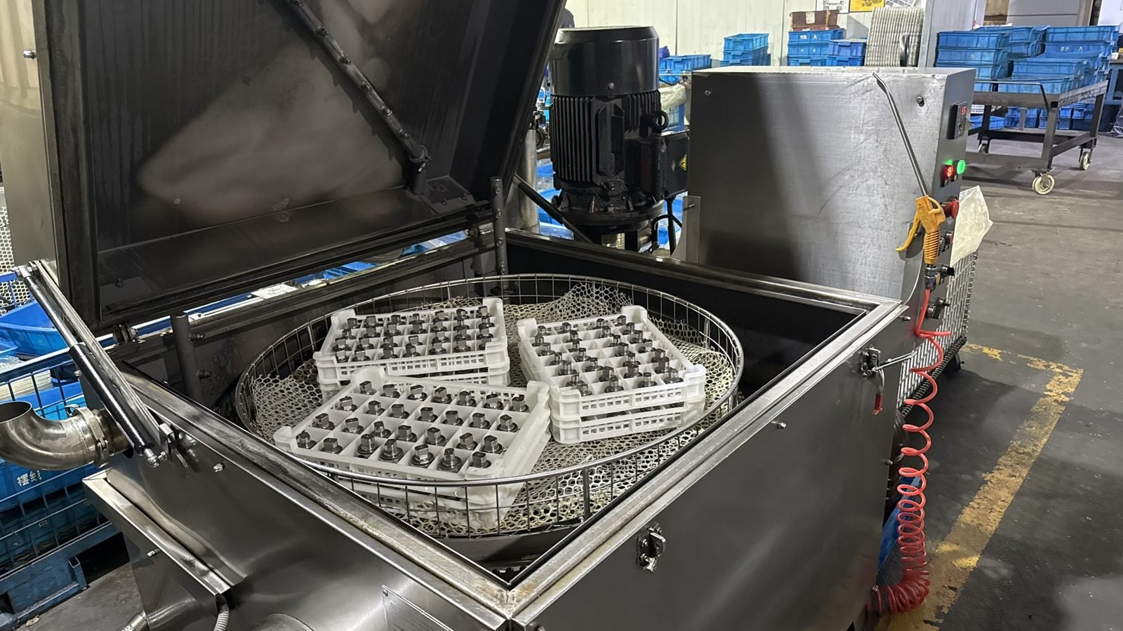 Industrial parts washer cleaning machined hydraulic motor components before assembly