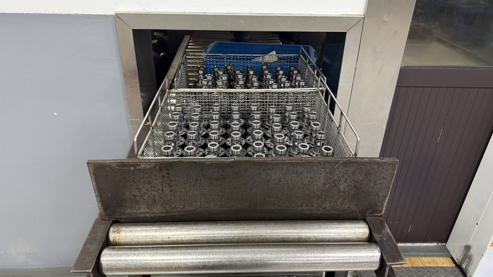 Washed hydraulic motor parts in a basket after the cleaning line
